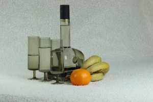Still life with a bottle and glasses and fruits  
